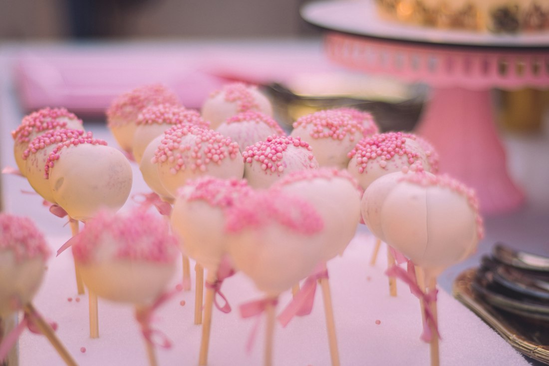 Pink and white cakecicles on a dessert stand