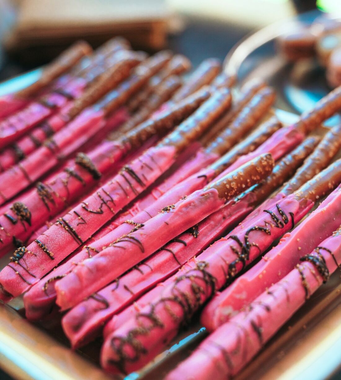 Chocolate-drizzled pretzel rods arranged on a tray
