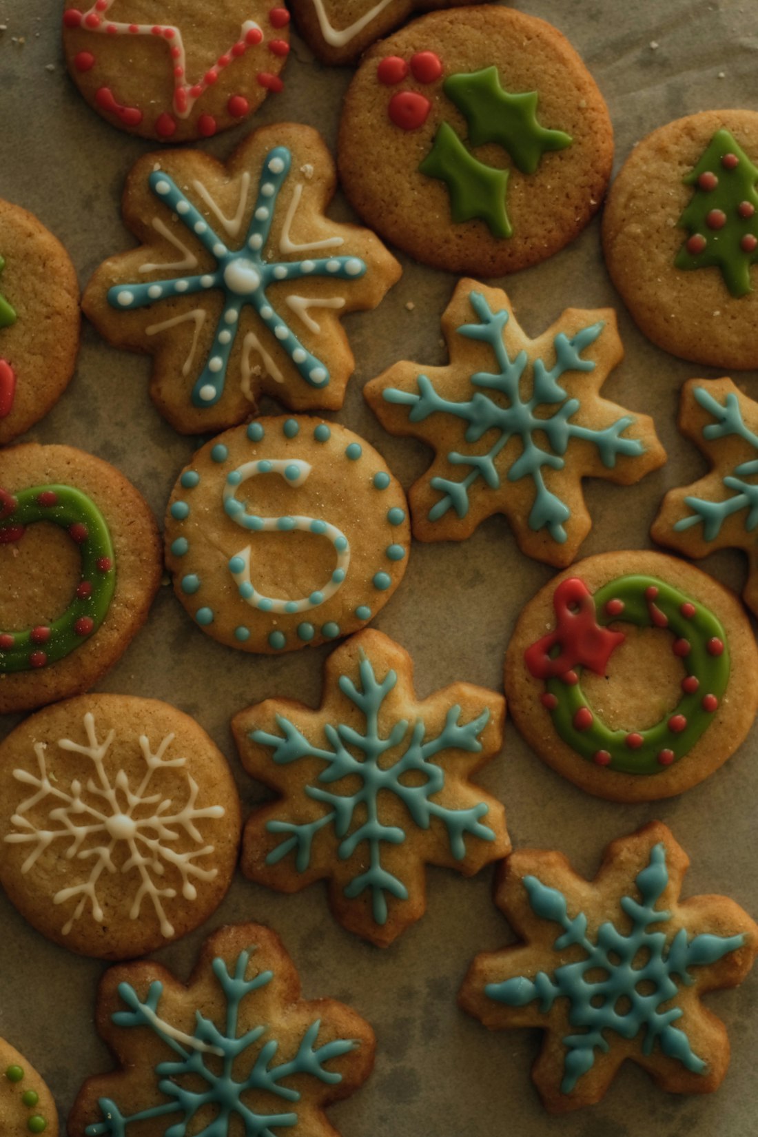 Hand-decorated sugar cookies cooling on parchment