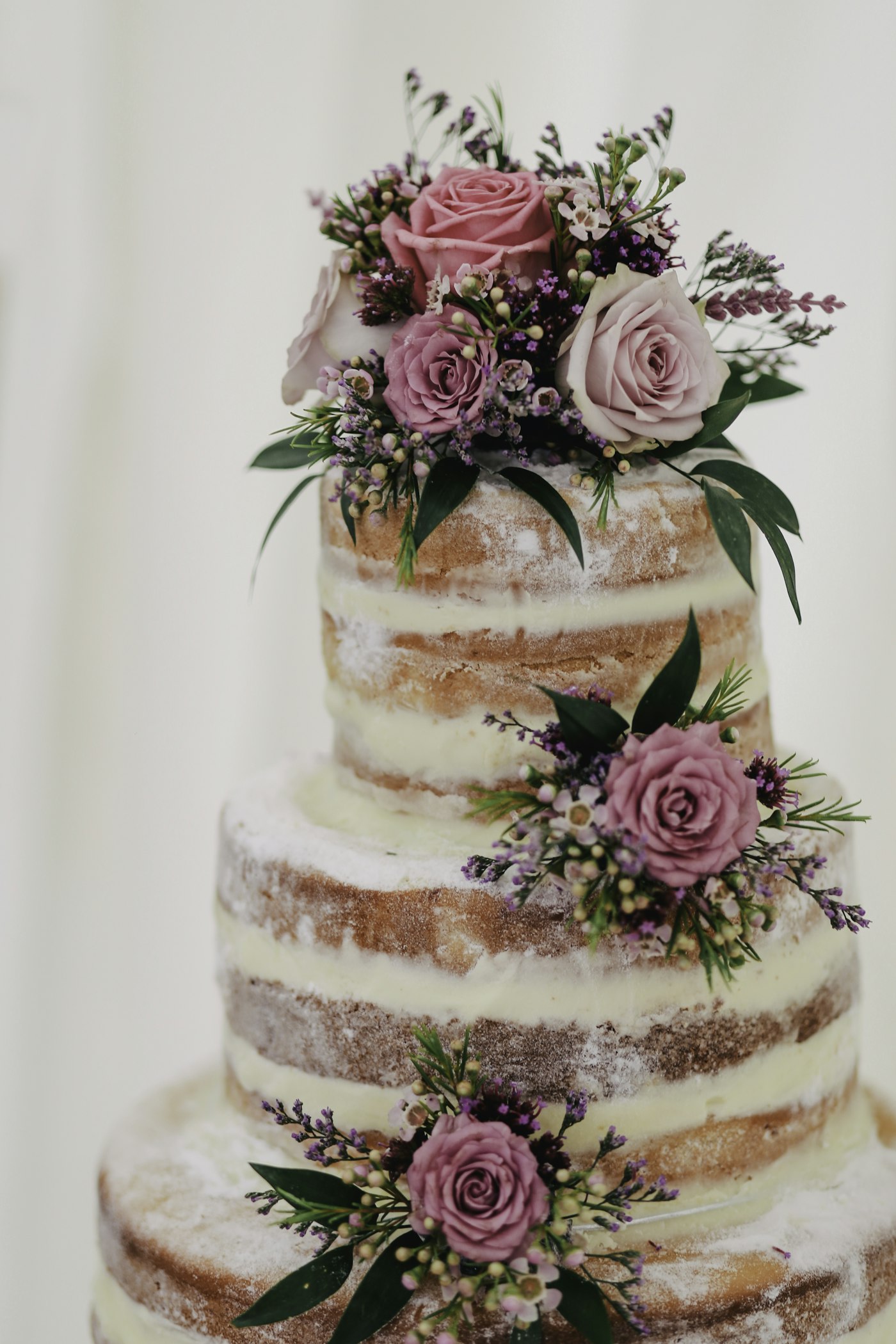 Tiered wedding cake finished with dusty rose and sage florals